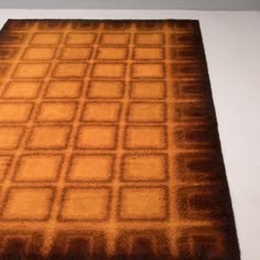 a brown area rug sitting on top of a white floor