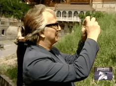 the man is holding his hands up in front of him while standing on some grass