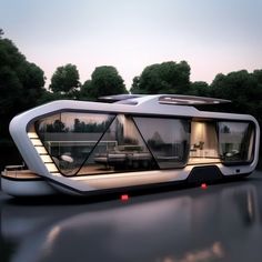 a futuristic house boat floating on top of a body of water with trees in the background