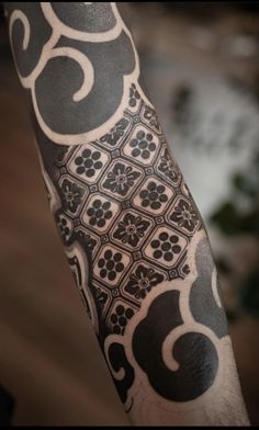 a man's arm with an intricate tattoo design on the left forearm and shoulder