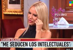 a woman talking on a cell phone while sitting in front of a tv screen with the caption'me seduen los inteluales '