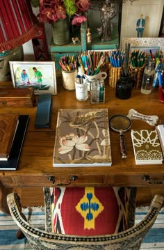 a wooden desk topped with lots of office supplies