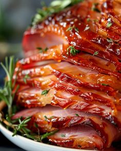 sliced ham on a white plate with herbs