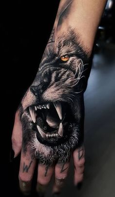 a man's hand with a wolf tattoo on it and an orange eye in the middle