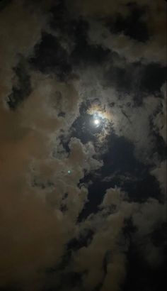 the moon is shining brightly in the cloudy sky