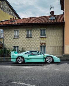 a blue sports car parked in front of a building