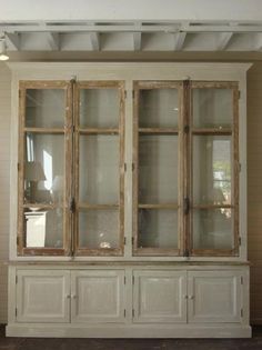 an old white china cabinet with glass doors