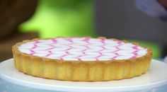 there is a small cake on top of a plate with pink and white icing