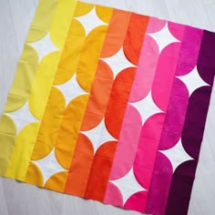 four different colors of paper with circles on them and one is pink, yellow, orange, green