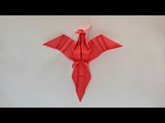 a red origami bird hanging on the wall