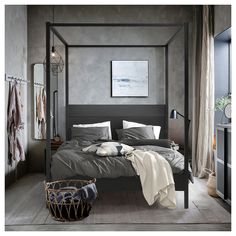 a bedroom with a four poster bed and grey walls