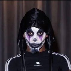 a man with white face paint and black hair