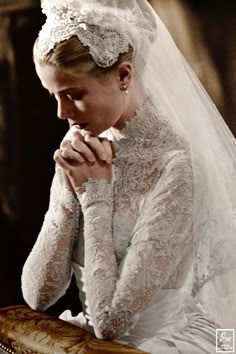 a woman in a wedding dress sitting on a bench with her hands clasped to her face