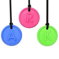 three different colored round tags with the letter k on one side and an initial on the other