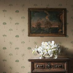 a vase with white flowers sitting on top of a dresser