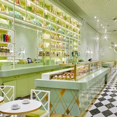 the interior of a restaurant with green and yellow walls, checkered flooring and white chairs