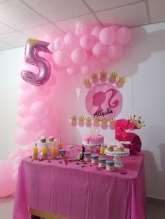 a table topped with lots of cake and balloons