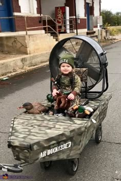 a little boy sitting on top of a small cart