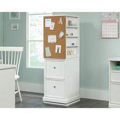 a white desk with a corkboard on it and two drawers in front of the door