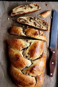 a loaf of bread sitting on top of a piece of wax paper next to a knife