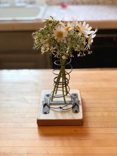 a vase filled with white flowers sitting on top of a wooden table