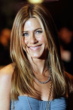 an image of a woman smiling at the camera with long hair and wearing a blue dress