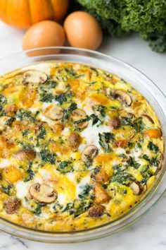 an omelet with mushrooms, spinach and cheese in a glass pie dish