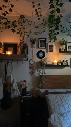 a bedroom with hanging plants and pictures on the wall above it, along with other decorations