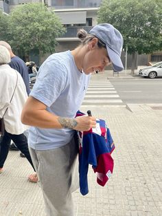 a woman is looking at her shirt on the street