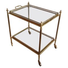 an antique brass serving cart with glass shelves