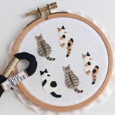 an embroidery project with cats and kittens on it's hoop, which is being displayed