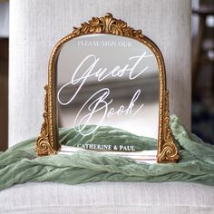 a mirror sitting on top of a white chair next to a green cloth covered pillow