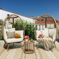 two wicker chairs sitting on top of a rug