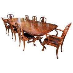 a large wooden dining table with six chairs and an oval shaped center piece on one end