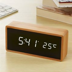 an alarm clock sitting on top of a wooden desk