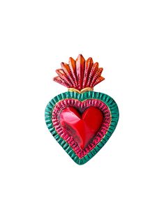 a red and green heart shaped brooch on a white backgroung background