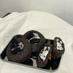 chocolate oreo cookies with white cream filling in a metal tray on a tablecloth