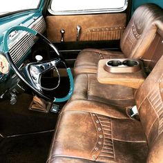 the interior of an old car with leather upholstered seats and steering wheel controls