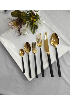 a white plate topped with black and gold utensils