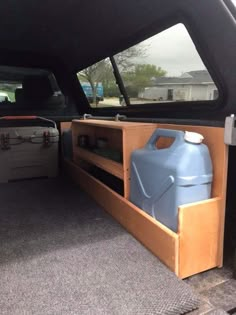 the back end of a truck with a large blue container in it's trunk