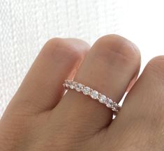 a woman's hand with a wedding ring on it, showing the diamond band