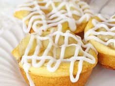 three cupcakes with white icing sitting on a plate