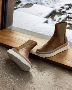 Pair of the France Boot in Caramello in the middle of a wooden doorway with a snowy landscape behind with the right shoe laying flat on the ground. Brown Leather Sole Chelsea Boots For Winter, Brown Waterproof Boots With Leather Sole, Modern Winter Boots With Leather Sole, Brown Winter Boots With Leather Sole, Brown Leather Waterproof Boots With Textured Sole, Clogs Heels, Pointed Boots, Clog Boots, Clog Heels