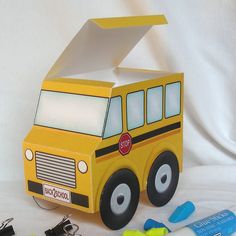 a school bus made out of construction paper and some tools to make it look like an origami