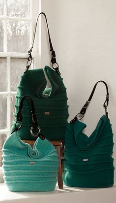 two purses sitting next to each other in front of a window