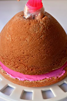 a chocolate cake with pink frosting on top