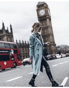 a woman crossing the street in front of big ben