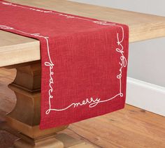 a red table runner on top of a wooden bench