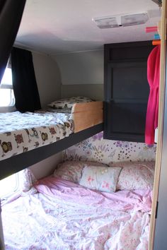 two bunk beds in a small room with pink and white sheets on the bedding