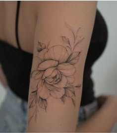 a woman's arm with a flower tattoo on it